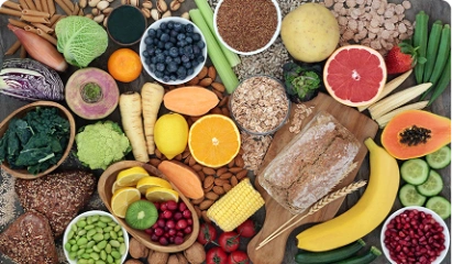 Colorful flat lay of fresh fruits, vegetables, grains, and seeds