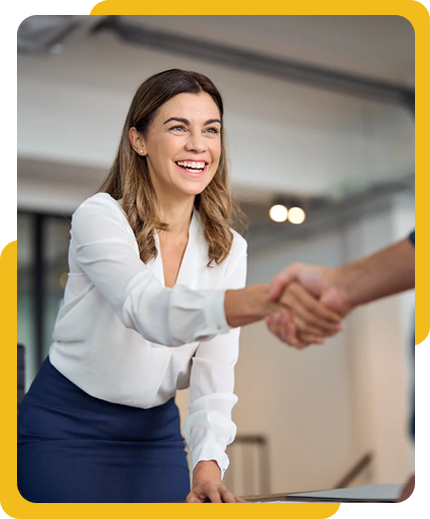 Smiling woman in a professional setting extending a handshake