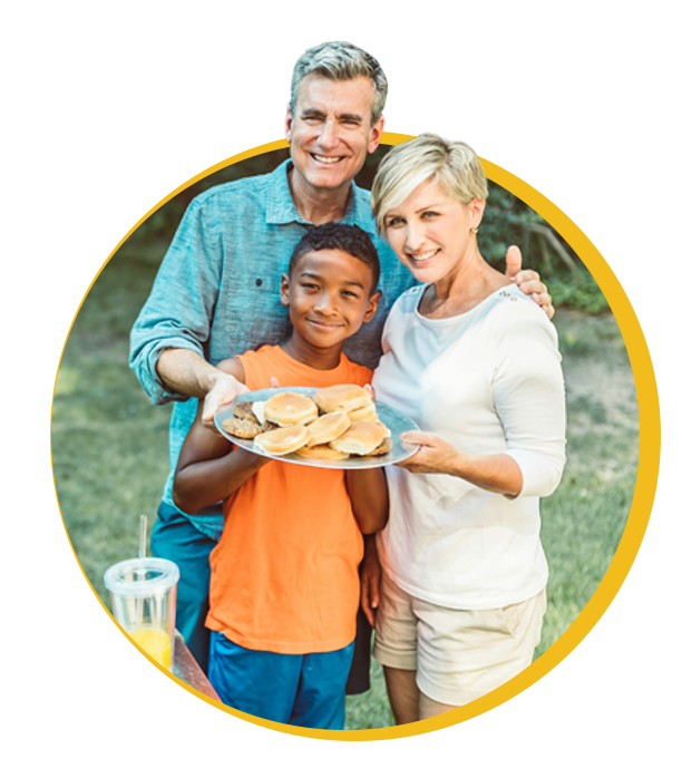 Smiling family holding a plate of healthy food outdoors