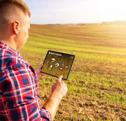 Man using a tablet to monitor crops in a field